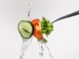 Fresh salad on fork splashed with water